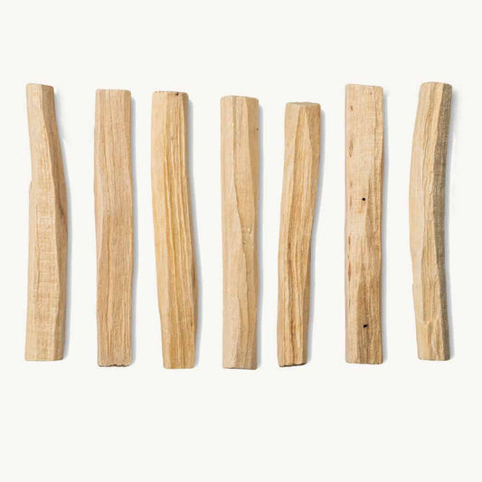 Seven wooden sticks of varying lengths arranged in a row on a white background