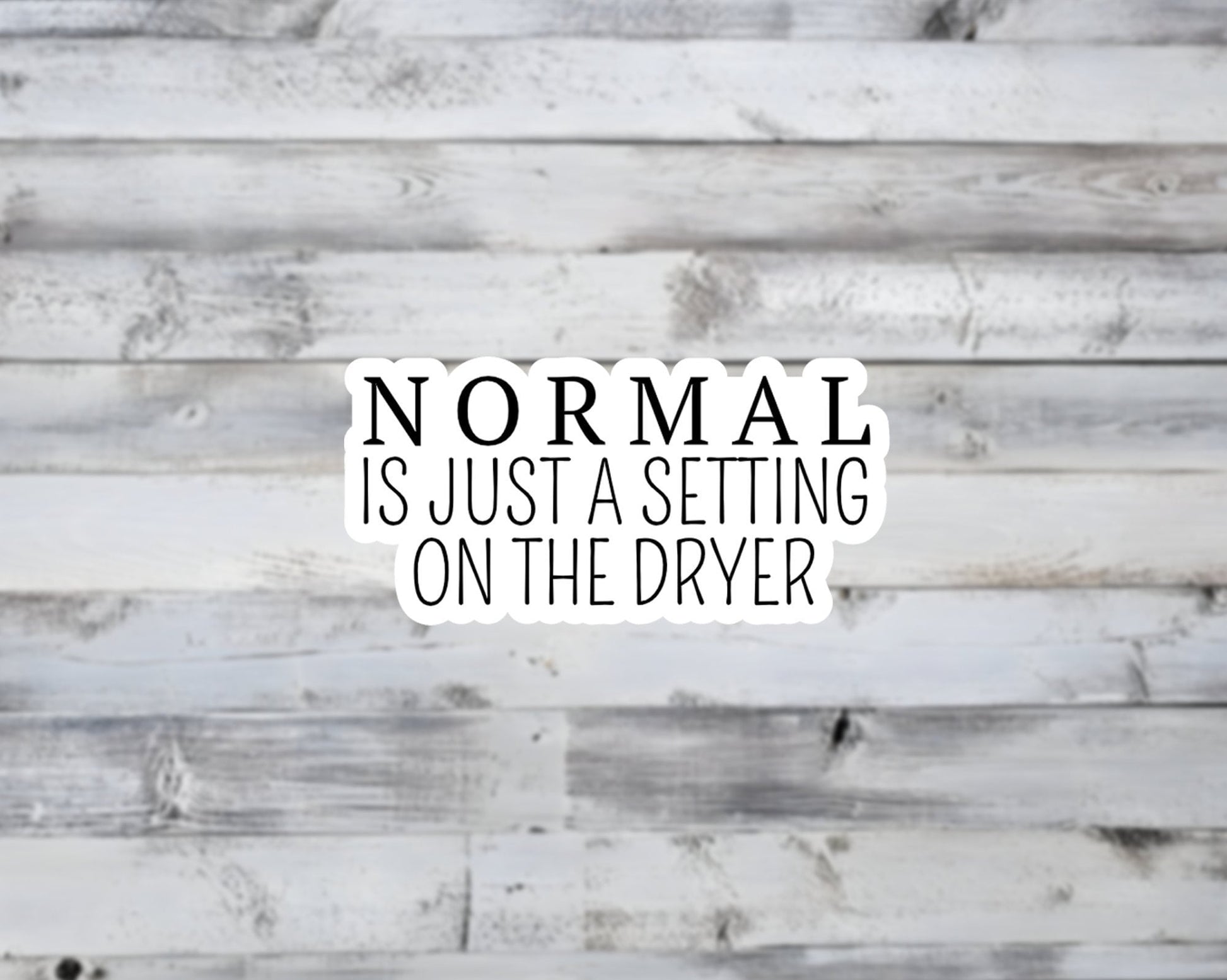 Text 'NORMAL IS JUST A SETTING ON THE DRYER' on a wooden background