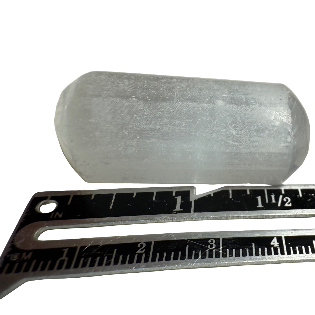 Cylindrical object  next to a ruler on a white background