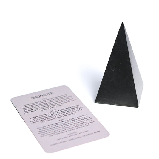 Black shungite pyramid with information card on a white background